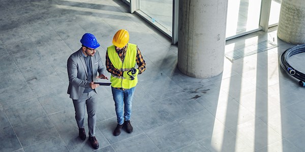 Two construction workers talking in a building